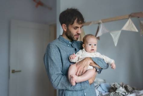 Father on paternity leave looking after his infant son at home