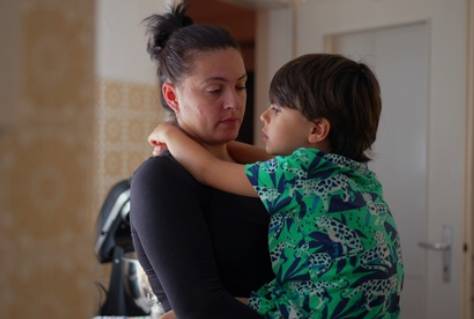 Mother holding child close, sharing a moment of connection and conversation in a cozy kitchen environment